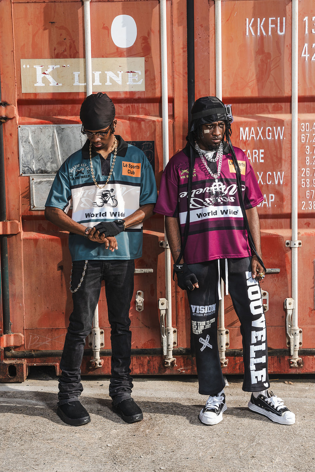 Two individuals standing in front of shipping containers with visible branding.
