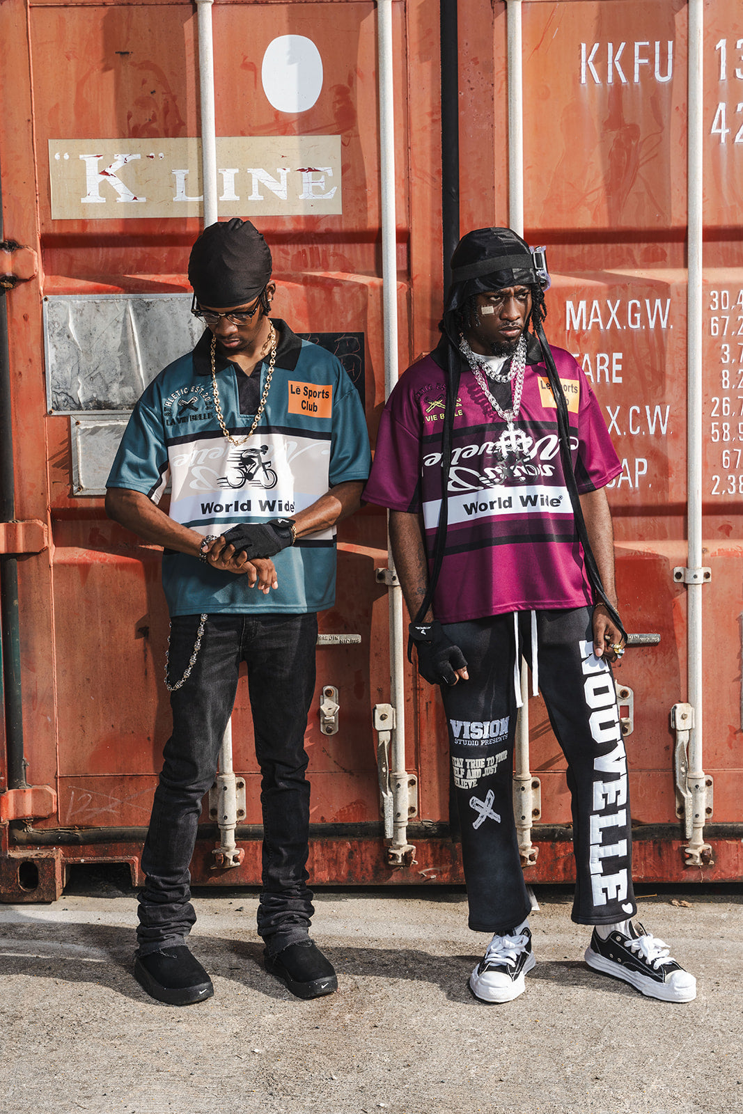Two individuals standing in front of shipping containers with visible branding.